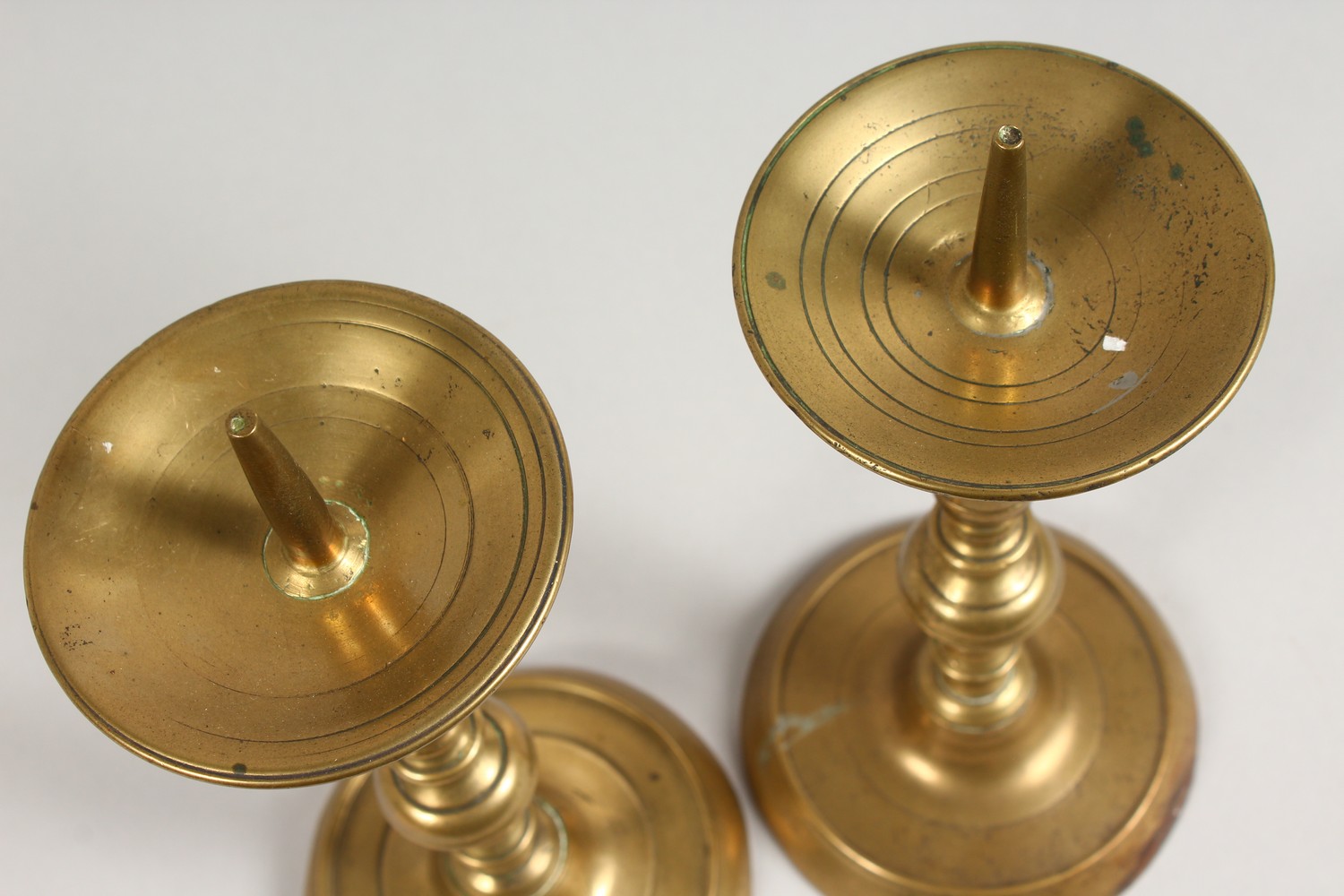 A PAIR OF EARLY BRASS CANDLESTICKS, with broad drip pans, on circular bases. 10ins high. - Image 3 of 4