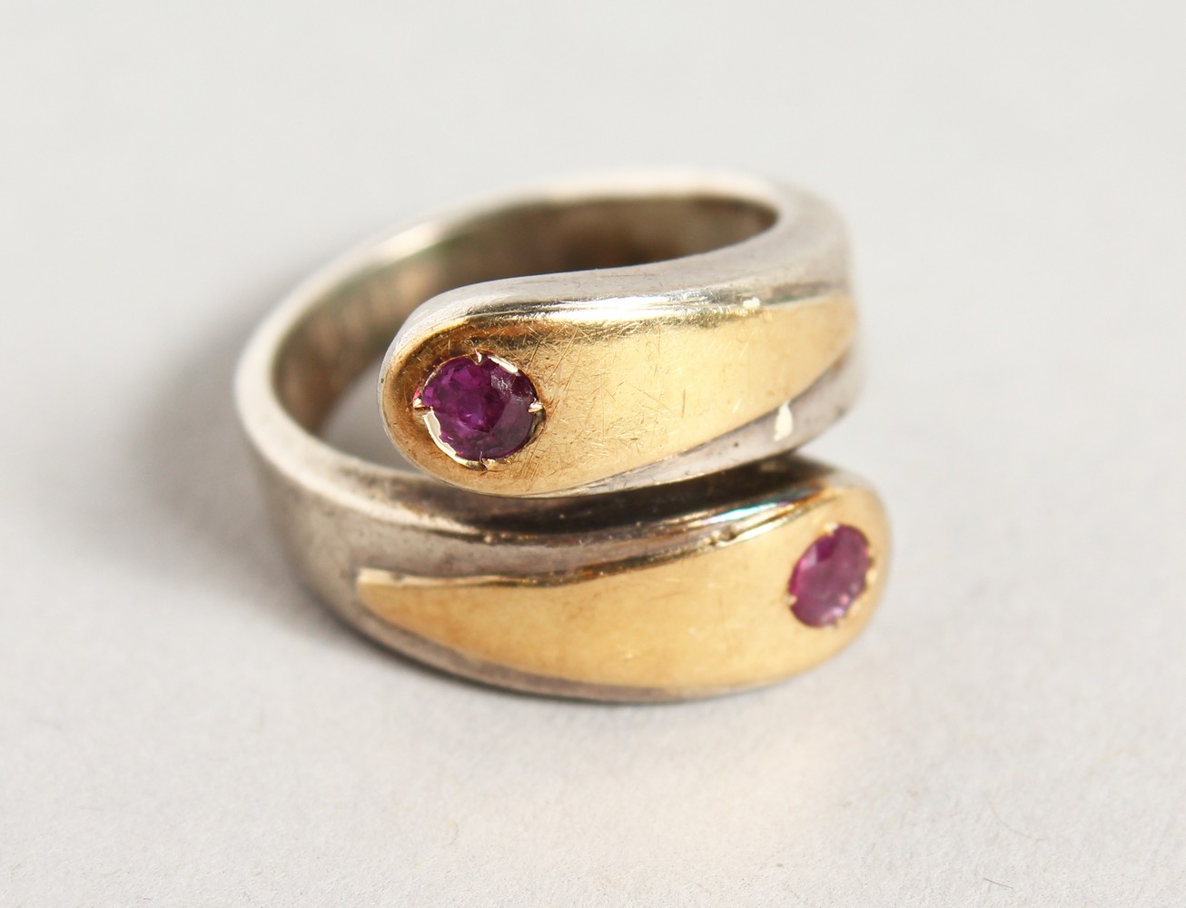 A STYLISH SILVER AND GOLD RING, set with two rubies.