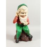 A PAINTED CAST COMPOSITE SEATED GNOME. 19ins high.