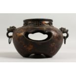 A BRONZE GOLD SPLASH CENSER, with pierced sides and ring handles. 10ins wide.