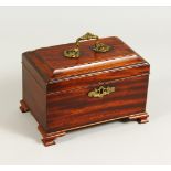 A GEORGE III MAHOGANY TEA CADDY, with ormolu handle and escutcheon, on ogee bracket feet. 9ins