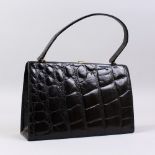 A BLACK CROCODILE HANDBAG.