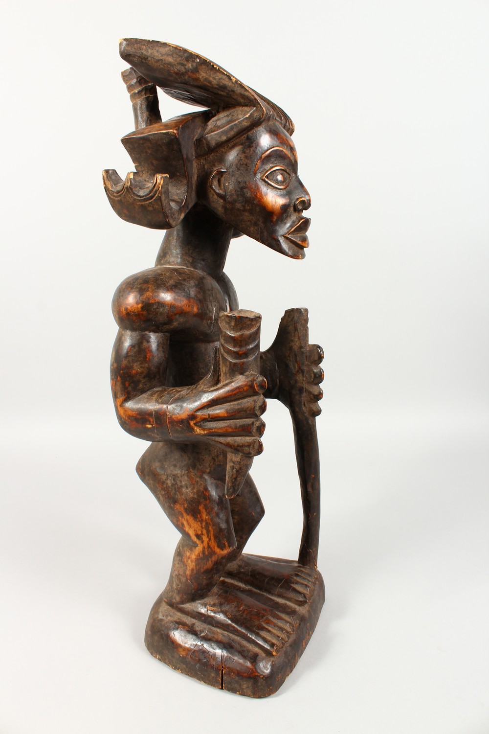A CARVED WOOD TRIBAL STANDING FIGURE, of a man with headdress, holding a staff. 23ins high. - Image 3 of 6