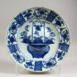 AN 18TH CENTURY DELFT CHARGER, painted with a basket of flowers. 13.5ins diameter.