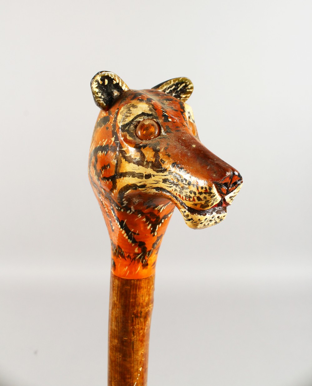 A WALKING STICK, the handle carved as a tiger. 52ins long.