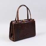 A BROWN CROCODILE HANDBAG.