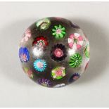 A CLICHY PAPERWEIGHT, with scattered cane decoration. 2.25ins diameter.