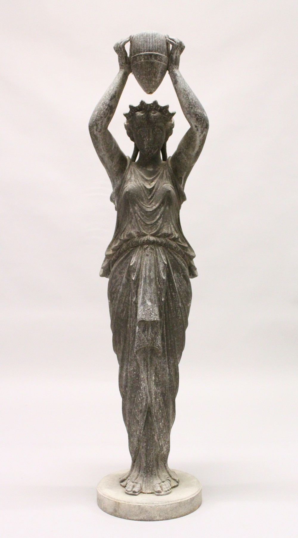 A 20TH CENTURY CAST SPELTER FIGURE OF A CLASSICAL LADY, holding aloft an urn, on a circular base (