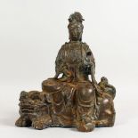 A CAST BRONZE GROUP OF AN EASTERN DEITY SEATED ON A DOG OF FO. 10.5ins high.