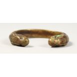 A ROMAN BRONZE BANGLE, with serpent terminals. 3ins diameter.