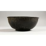 A BYZANTINE BRONZE BOWL, the rim with incised inscription. 7ins diameter.