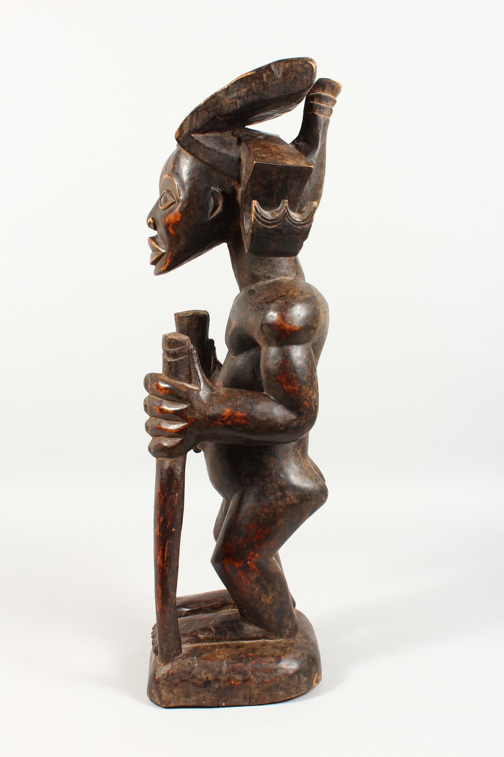 A CARVED WOOD TRIBAL STANDING FIGURE, of a man with headdress, holding a staff. 23ins high. - Image 5 of 6