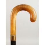 A RHINO HORN HANDLED WALKING STICK with metal collar. 36.5ins long.