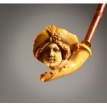 A MEERSCHAUM PIPE, the bowl carved as a woman wearing a hat. 10ins long.