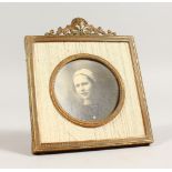 A SMALL EMPIRE STYLE GILT METAL PHOTOGRAPH FRAME, with ornate crestings. 5ins high x 4ins wide.