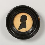 A CIRCULAR SILHOUETTE OF A YOUNG BOY, in an ebony frame. 4ins diameter.