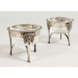A PAIR OF FRENCH SILVER CIRCULAR GLASS SALTS, with rams masks. 2.75ins diameter.