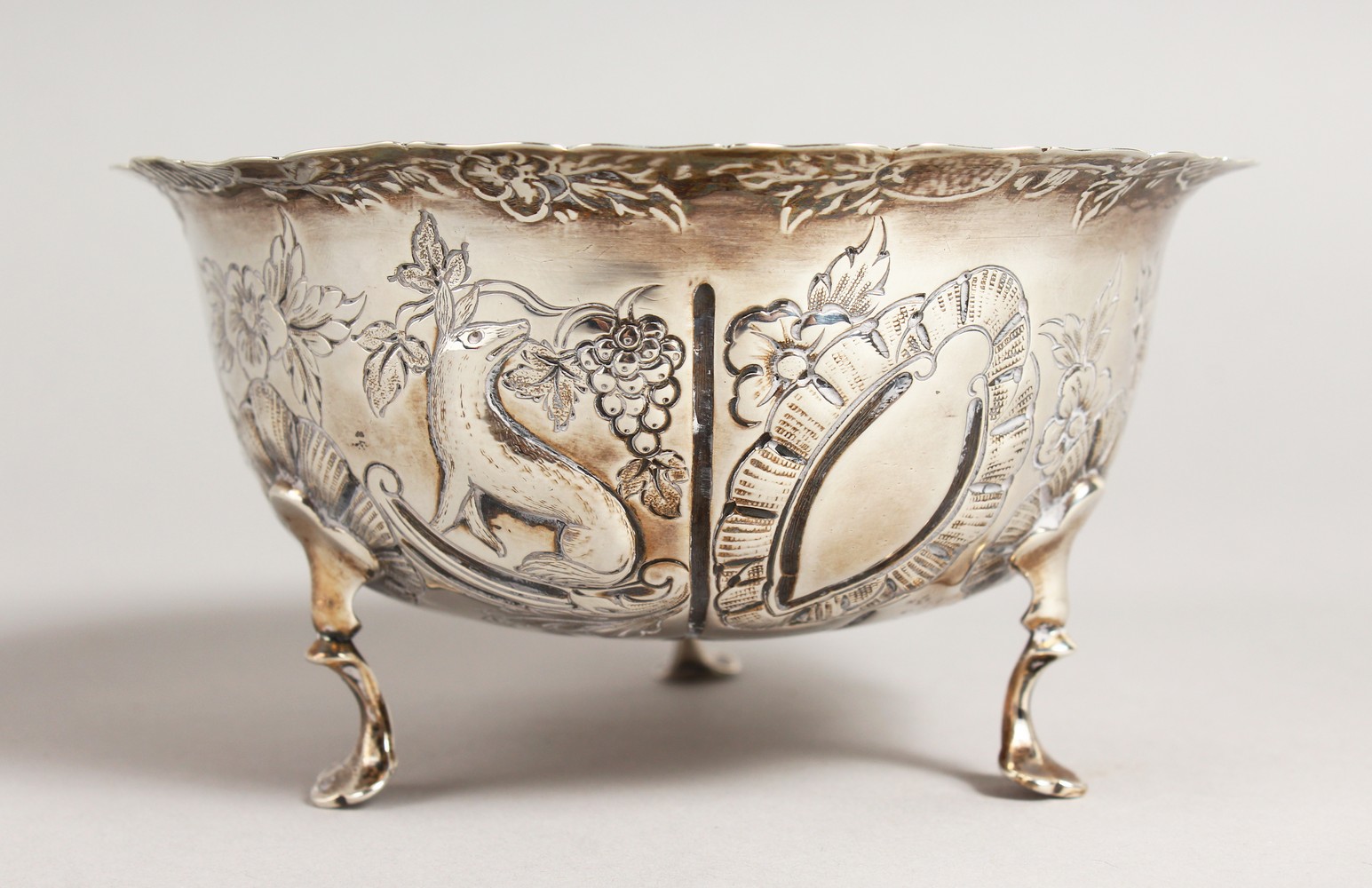 A VICTORIAN CIRCULAR SUGAR BOWL, repousse with birds, animals etc., on three pad feet. 4.75ins