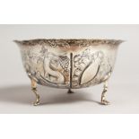 A VICTORIAN CIRCULAR SUGAR BOWL, repousse with birds, animals etc., on three pad feet. 4.75ins