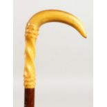 A CARVED RHINO HORN HANDLED WALKING STICK. 36ins long.