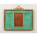 AN EMPIRE STYLE GILT METAL RECTANGULAR PHOTOGRAPH FRAME, with ornate cresting. 9.5ins high x 11.5ins