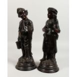 A PAIR OF CONTINENTAL BROWN GLAZED TERRACOTTA FIGURES OF A BOY AND GIRL. 13ins high.
