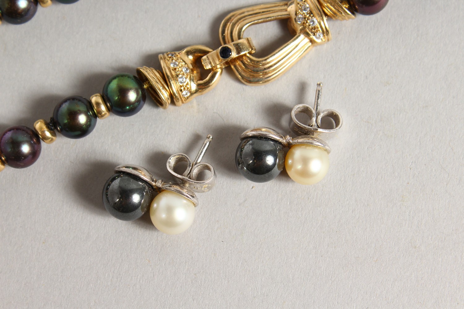 A GOOD BLACK PEARL NECKLACE, with ornate gold and diamond clasp, with a pair of similar earrings. - Image 2 of 5