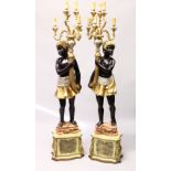 A PAIR OF FLOOR STANDING CANDELABRA, modelled as Blackamoors. 6ft 4ins high.