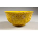 A YELLOW GROUND CIRCULAR BOWL, with moulded decoration. 6ins diameter.