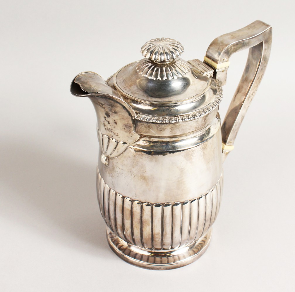 A GEORGE III SEMI FLUTED JUG, with gadrooned edge, crested. London 1815. Maker: R.E. Weight 22ozs.