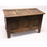 AN 18TH CENTURY OAK COFFER, with triple panelled top and front, with carved decoration. 3ft 8ins