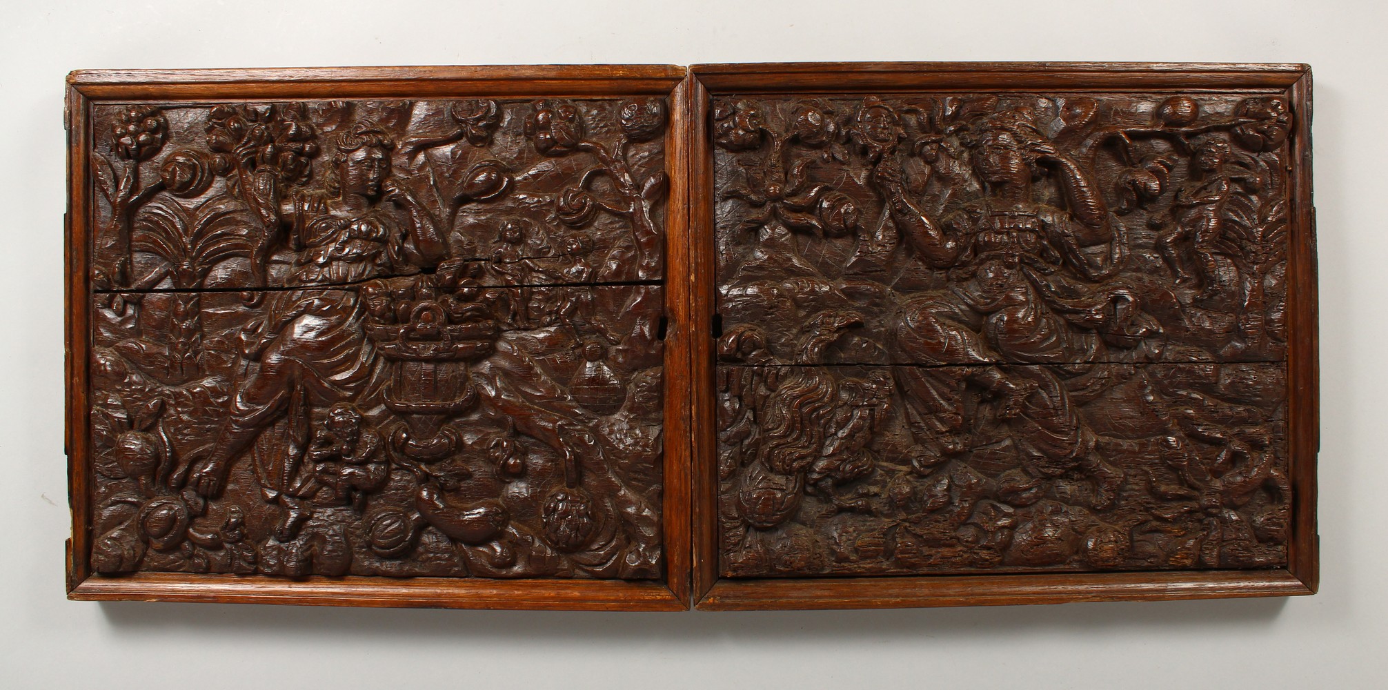 A GOOD PAIR OF EARLY CARVED OAK PANELS, POSSIBLY 17TH CENTURY, depicting female figures, children,