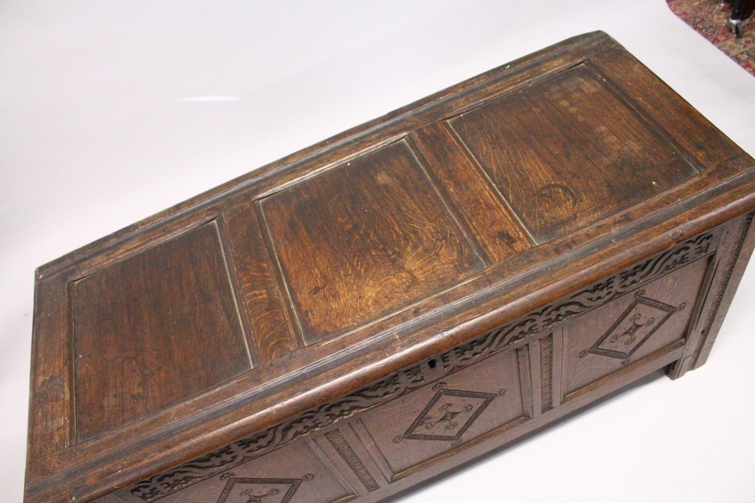AN 18TH CENTURY OAK COFFER, with triple panelled top and front, with carved decoration. 4ft 3ins - Image 3 of 4