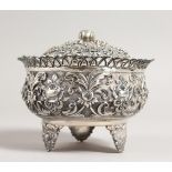 AN INDIAN WHITE METAL BOWL AND COVER, with pierced rim and embossed decoration. 4.5ins diameter.
