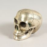 A SILVER PLATED MODEL OF A SKULL. 5ins long.