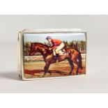 A SILVER RECTANGULAR PILL BOX, the lid with an enamel horse and jockey. 1.75ins long.
