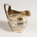 A GEORGE III MILK JUG, with repousse decoration. London 1803.