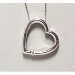 A 9CT WHITE GOLD HEART SHAPED DIAMOND SET PENDANT NECKLACE in the Tiffany style.