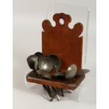 AN OAK SPOON RACK, with ten pewter spoons. 10.5ins high.