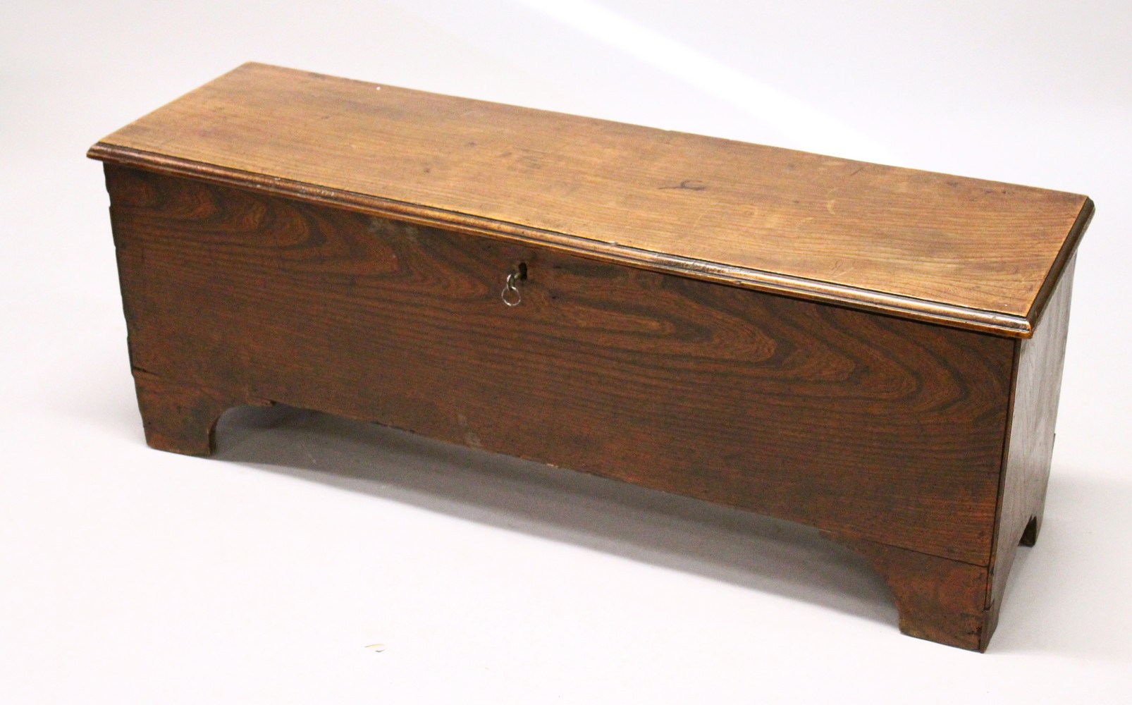 AN 18TH CENTURY ELM SIX PLANK COFFER, on bracket feet. 4ft 0ins long x 14ins wide x 1ft 6ins high.