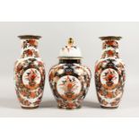 A JAPANESE IMARI GARNITURE, comprising a pair of vases and ginger jar and cover. Vases: 10.5ins