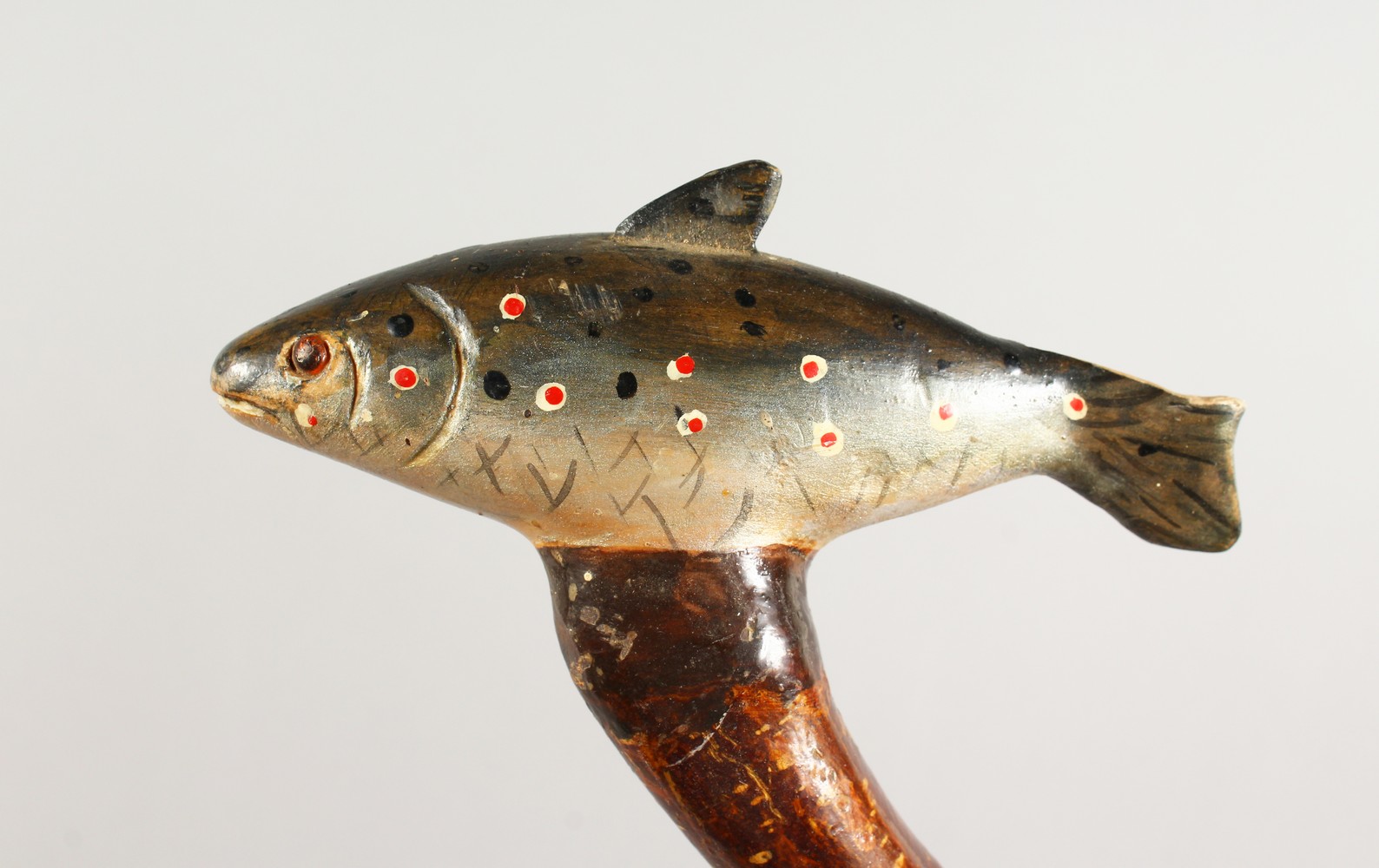 A WALKING STICK, the handle carved as a trout. 51ins long.