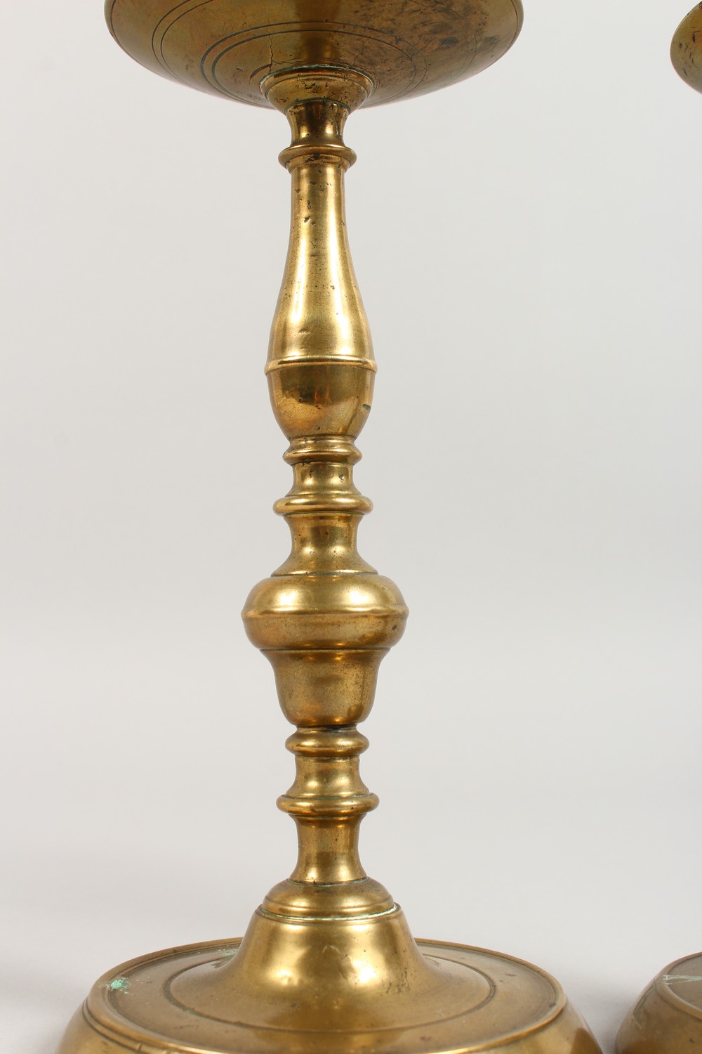 A PAIR OF EARLY BRASS CANDLESTICKS, with broad drip pans, on circular bases. 10ins high. - Image 2 of 4