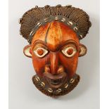 A CARVED AND PAINTED AFRICAN TRIBAL MASK, with plaited hair and beard. 15ins high.