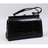 A BLACK CROCODILE HANDBAG.