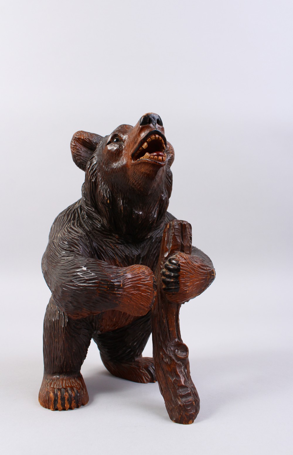 A GOOD 19TH CENTURY BLACK FOREST CARVED WOOD STANDING BEAR CADDY, with hinged head. 11ins high.