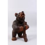 A GOOD 19TH CENTURY BLACK FOREST CARVED WOOD STANDING BEAR CADDY, with hinged head. 11ins high.