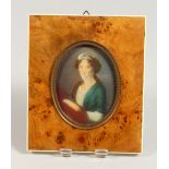 AN OVAL PORTRAIT MINIATURE, young lady with a green shawl, in a burr wood frame. 5.5ins x 4.75ins.