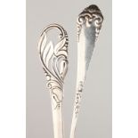 TWO LARGE CONTINENTAL SERVING SPOONS, with decorative handles. 10ins and 11.5ins long.
