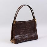 A BROWN CROCODILE HANDBAG.